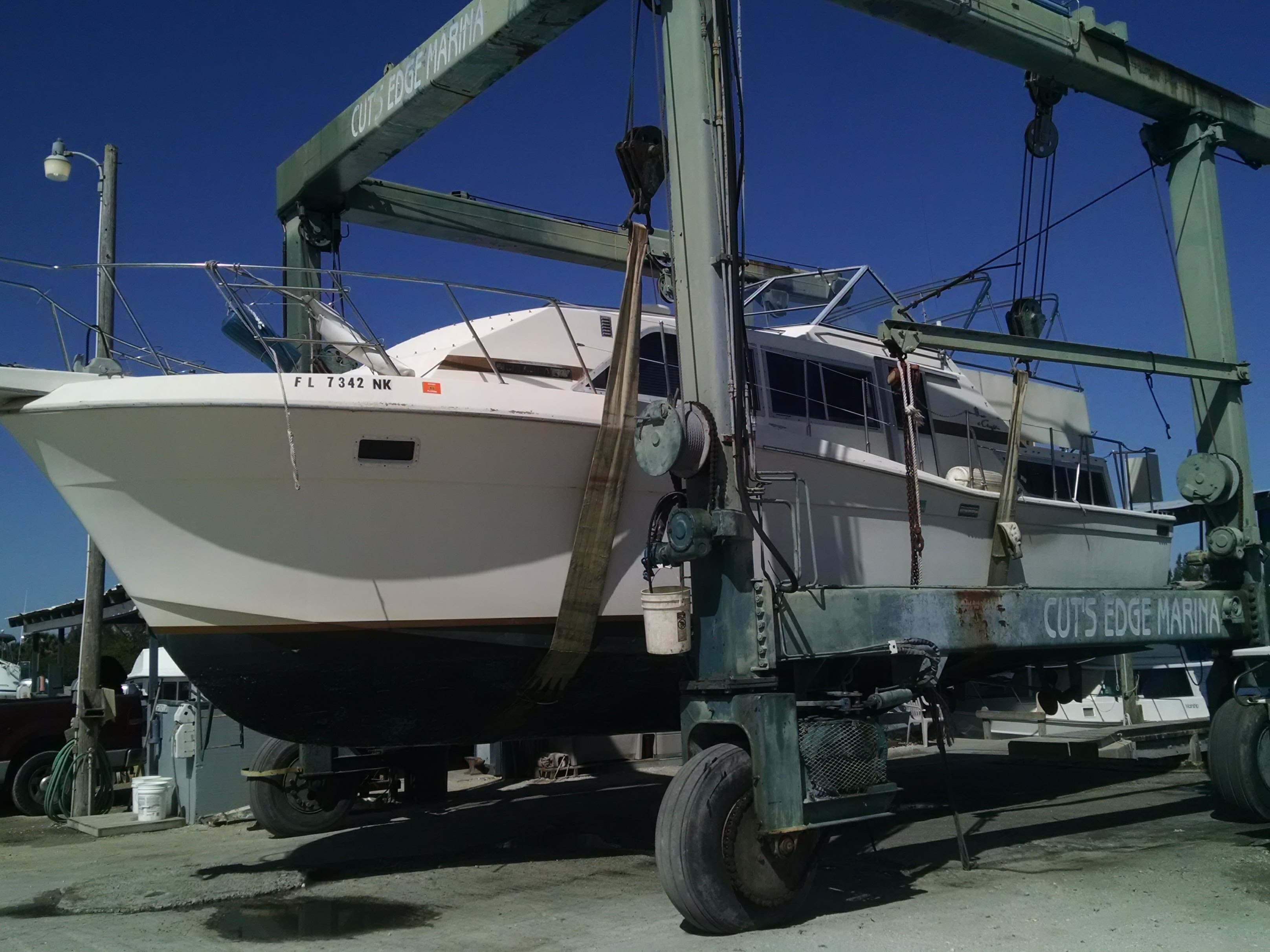 A boat lifted clear of the water by Cut's Edge Harbor Marina's 30-ton travel lift